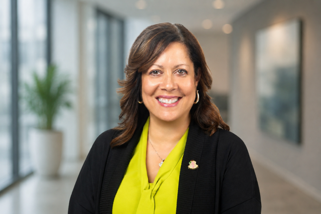 Jamie Gordon smiling, wearing a lime blouse and black cardigan.